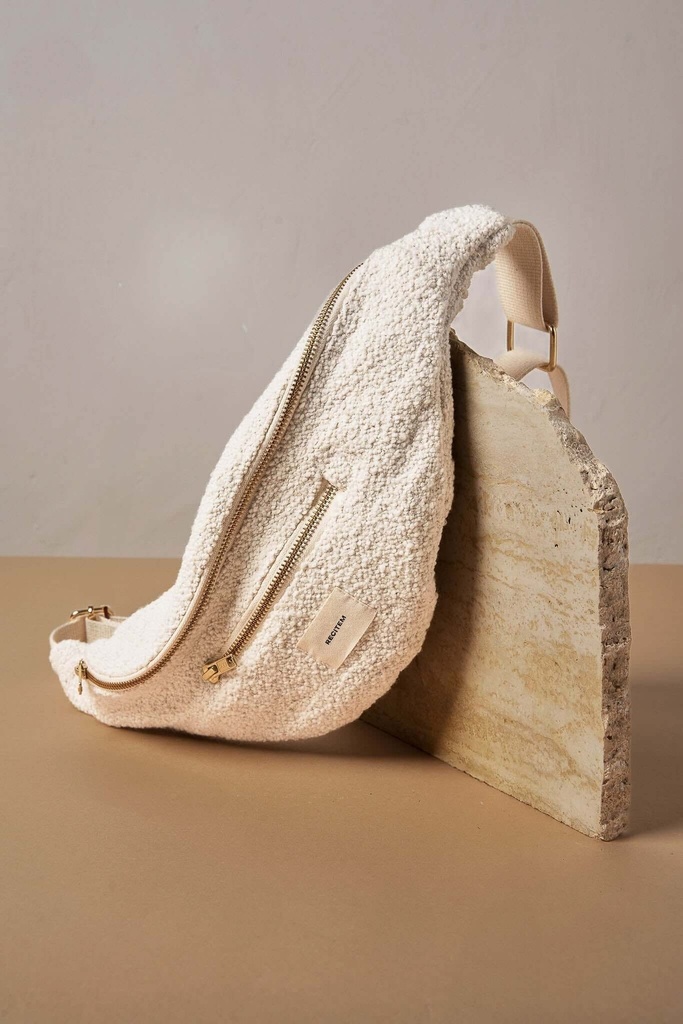 sac banane écru bouclette posé sur une table